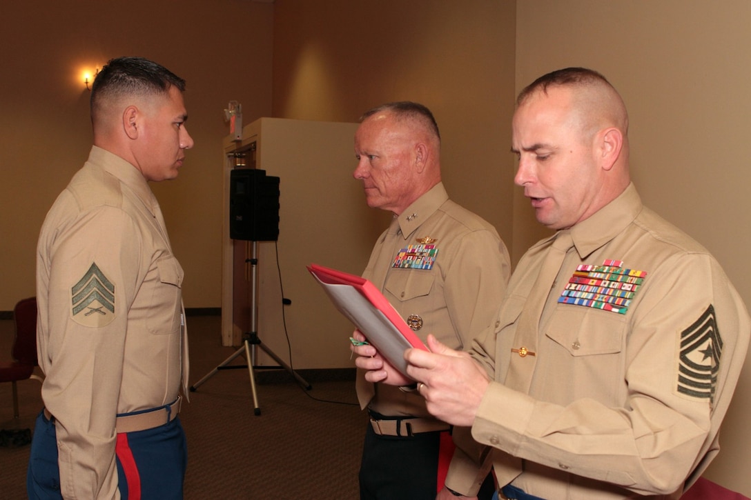 Sergeant Maj. David L. Jobe, 1st Marine Division sergeant major, right, reads the award citation for the the Navy and Marine Corps Achievement Medal presented by Maj. Gen. Larry D. Nicholson, center, 1st Marine Division commanding general, to Sgt. Marcos A. Valentin, career planner, 1st Reconnaissance Battalion, after being named “Career Planner of the Year” for 1st Marine Division during the 1st Marine Division Annual Career Planning Awards Luncheon at Marine Corps Base Camp Pendleton, Calif., Jan. 27, 2014. Valentin, a 27-year-old native of Mira Mesa, San Diego, and 2004 graduate of Mira Mesa High School, met his retention goal of more than 200 percent during 2013. He is required to interview each Marine at least two to three times during their careers. In order to accommodate their busy training and deployment schedules, he interviewed many of them during field training and also during early mornings and late nights. Valentin reported to Marine Corps Recruit Depot San Diego for recruit training nearly nine years ago, Mar. 7, 2005. He plans to make the Marine Corps a career. 
(U.S. Marine Corps photo by Sgt. Jacob H. Harrer / released)
