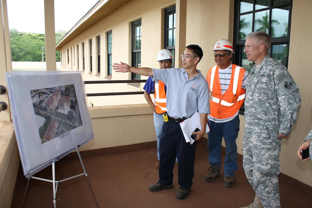 Mechanical Engineer and project manager for the Schofield Barracks Warrior In Transition construction project shows Pacific Ocean Division Commander Maj. Gen. Richard L. Stevens an artist's rendering of the project layout from a vantage point just above the actual project site. 