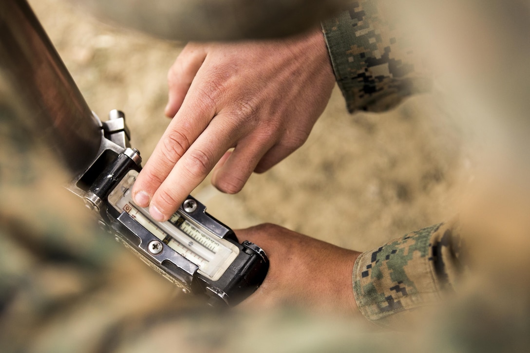 Pfc. Paul Dingess taps on the range indicator while Pfc. Michael Baldwin holds the 60mm mortar cannon while they practice using the handheld unit during a training exercise at Camp Pendleton on Jan. 30. Baldwin and Dingess are students with Delta Company, Infantry Training Battalion, School of Infantry-West and is training to be a 0341 mortar men. 

Infantry Training Battalion trains all infantry, entry-level Marines in the infantry skills essential to operating combat environment. Infantry Training Battalion is a 52-day training course that transforms the raw Marine into an infantryman who can fight, survive, and win in a combat situation. 

