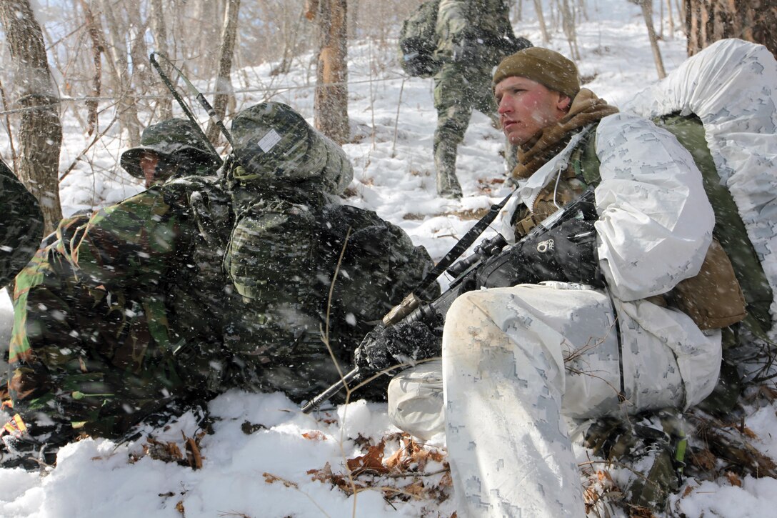 Gunnery Sgt. Matthew C. Luckey provides cover while Republic of Korea Marines radio for assistance prior to a raid in an area where simulated enemy activity was spotted Jan. 22 during Korean Marine Exchange Program 14-3 at the Mountain Warfare Training Camp in Pyeongchang, Republic of Korea. As part of KMEP, the Marines cross-trained in a multitude of cold-weather skills and missions such as skiing, assaults, patrols and raids. The raid is part of the training evolutions leading up to a 400-kilometer hike. Luckey is a platoon sergeant with 3rd Reconnaissance Battalion, 3rd Marine Division, III Marine Expeditionary Force. The ROK Marines are with the 1st ROK Special Reconnaissance Battalion, 1st ROK Division. Photo by Lance Cpl. Matt Myers