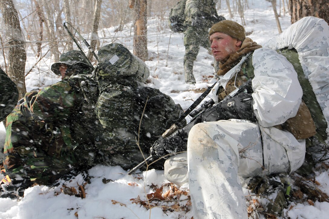 Gunnery Sgt. Matthew C. Luckey provides cover while Republic of Korea Marines radio for assistance prior to a raid in an area where simulated enemy activity was spotted Jan. 22 during Korean Marine Exchange Program 14-3 at the Mountain Warfare Training Camp in Pyeongchang, Republic of Korea. As part of KMEP, the Marines cross-trained in a multitude of cold-weather skills and missions such as skiing, assaults, patrols and raids. The raid is part of the training evolutions leading up to a 400-kilometer hike. Luckey is a platoon sergeant with 3rd Reconnaissance Battalion, 3rd Marine Division, III Marine Expeditionary Force. The ROK Marines are with the 1st ROK Special Reconnaissance Battalion, 1st ROK Division. 