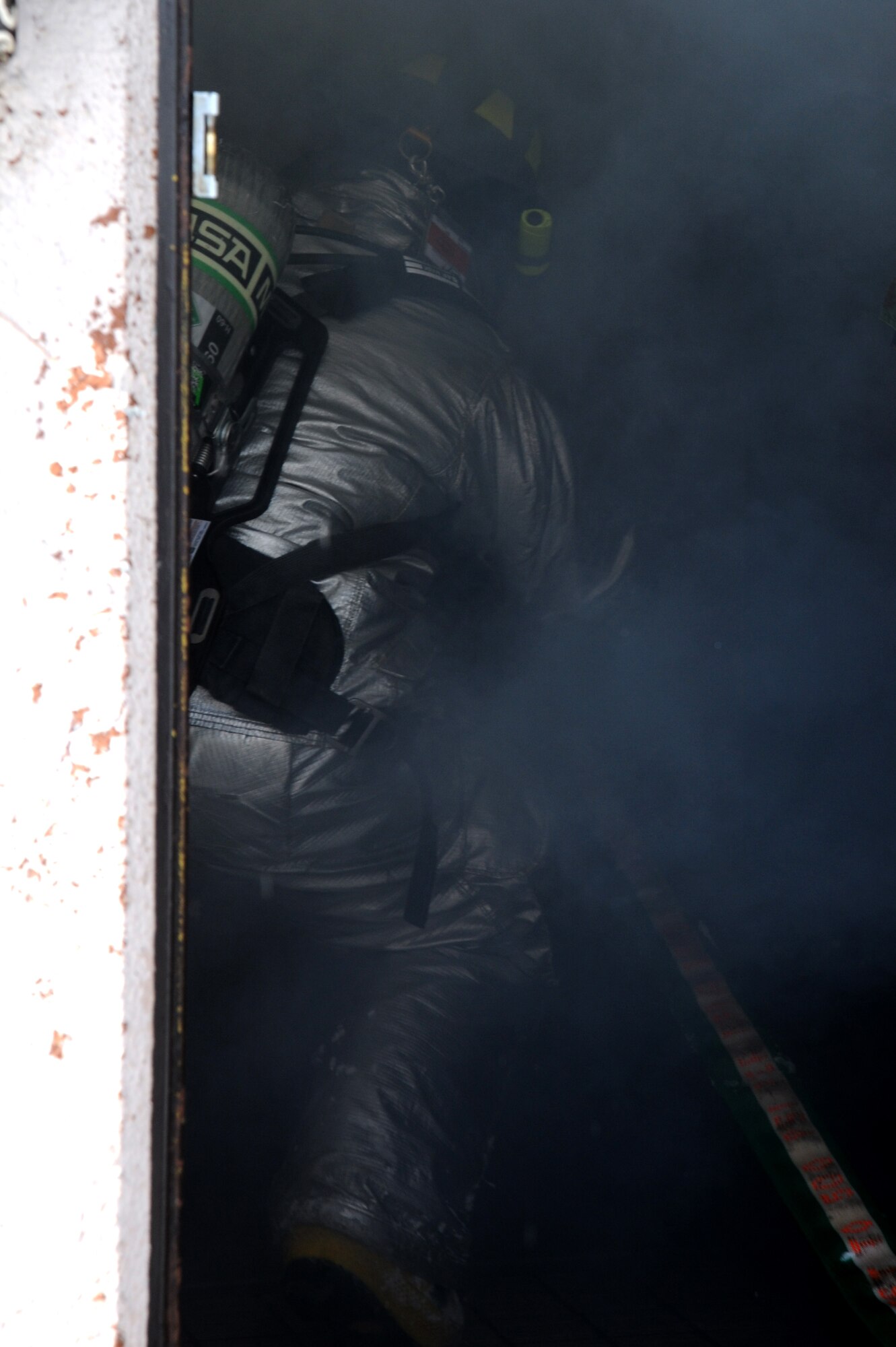 U.S. Air Force Airman 1st Class Benny Bowen, 35th Civil Engineer Squadron firefighter, enters a room filled with blinding smoke in search of two fallen wingmen during Phase II of the operational readiness exercise on Misawa Air Base, Japan, Jan. 29, 2014.  The firefighters ensured the scene was safe then began the right-hand search pattern throughout the simulated burning building in search of the two down wingmen. (U.S. Air Force photo/Tech. Sgt. April Quintanilla)