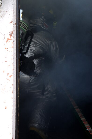U.S. Air Force Airman 1st Class Benny Bowen, 35th Civil Engineer Squadron firefighter, enters a room filled with blinding smoke in search of two fallen wingmen during Phase II of the operational readiness exercise on Misawa Air Base, Japan, Jan. 29, 2014.  The firefighters ensured the scene was safe then began the right-hand search pattern throughout the simulated burning building in search of the two down wingmen. (U.S. Air Force photo/Tech. Sgt. April Quintanilla)