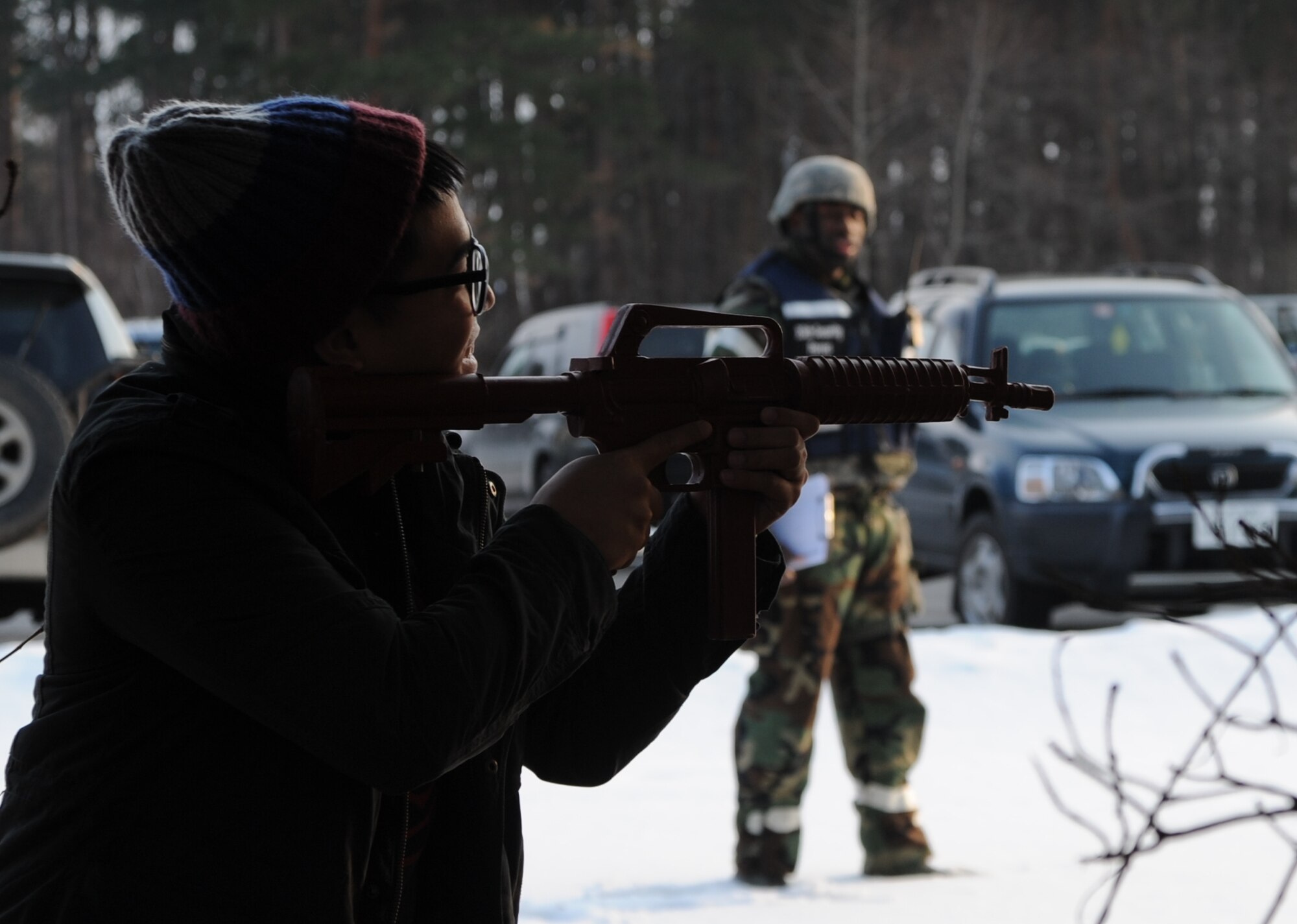 U.S. Airman 1st Class John Rodil, 35th Security Forces basic force protector, fires upon a 35 SFS patrol car while 35 SFS wing inspection team evaluates the attack during Phase II of the operational readiness exercise at Misawa Air Base, Japan, Jan. 28, 2014. Members of 35 SFS are selected to be base aggressors and simulate attacks their wingmen to make each scenario realistic.  (U.S. Air Force photo/Tech. Sgt. April Quintanilla)