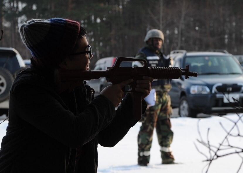 U.S. Airman 1st Class John Rodil, 35th Security Forces basic force protector, fires upon a 35 SFS patrol car while 35 SFS wing inspection team evaluates the attack during Phase II of the operational readiness exercise at Misawa Air Base, Japan, Jan. 28, 2014. Members of 35 SFS are selected to be base aggressors and simulate attacks their wingmen to make each scenario realistic.  (U.S. Air Force photo/Tech. Sgt. April Quintanilla)