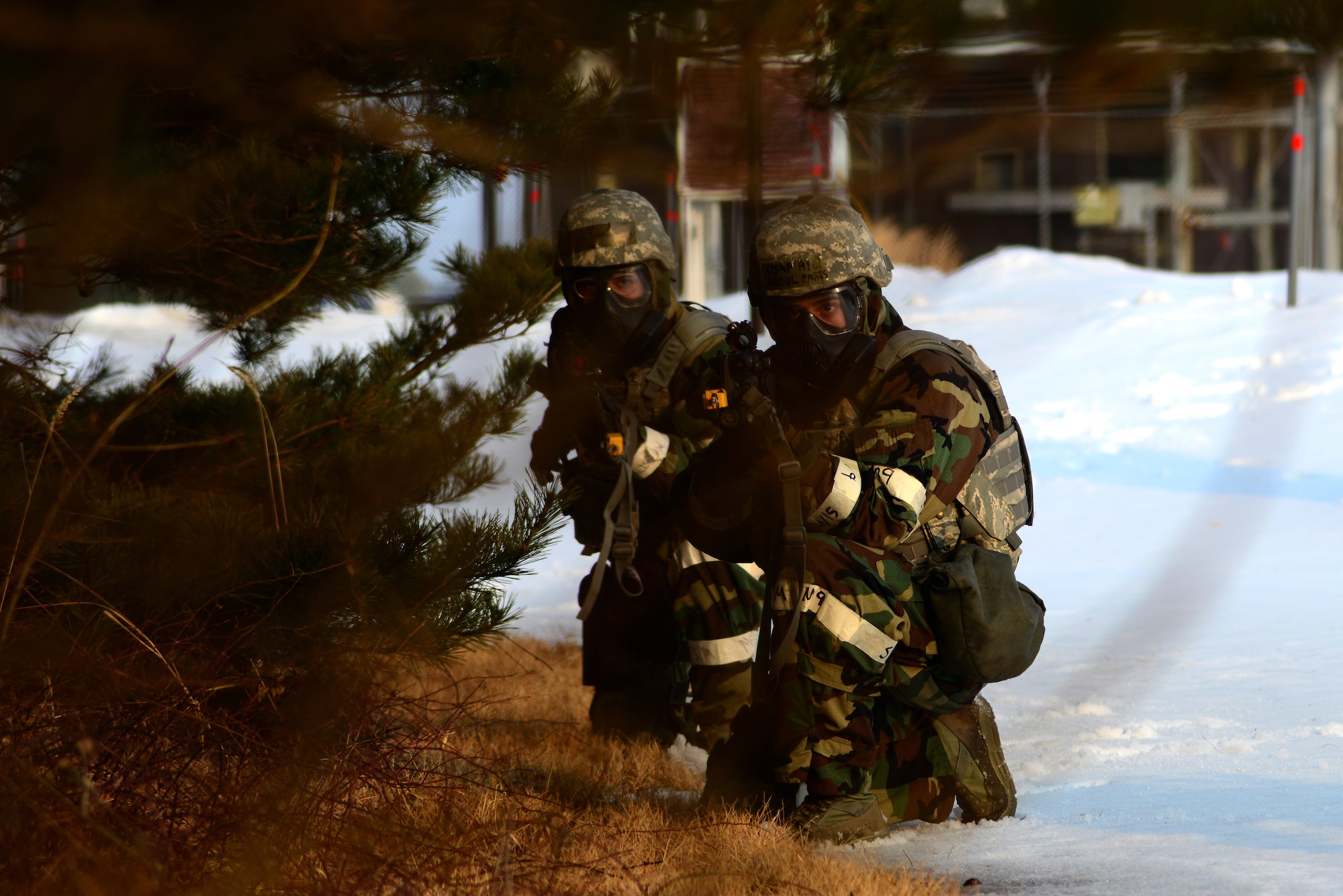 U.S. Air Force Airman 1st Class Abdul Fares and Senior Airman Jeremy Johnson, 35th Security Forces force protectors, simulate taking aim as they pursue an attacker during Phase II of the operational readiness exercise at Misawa Air Base, Japan, Jan. 28, 2014. Security forces members train to handle attackers that breech the perimeter. (U.S. Air Force photo/Tech. Sgt. April Quintanilla)