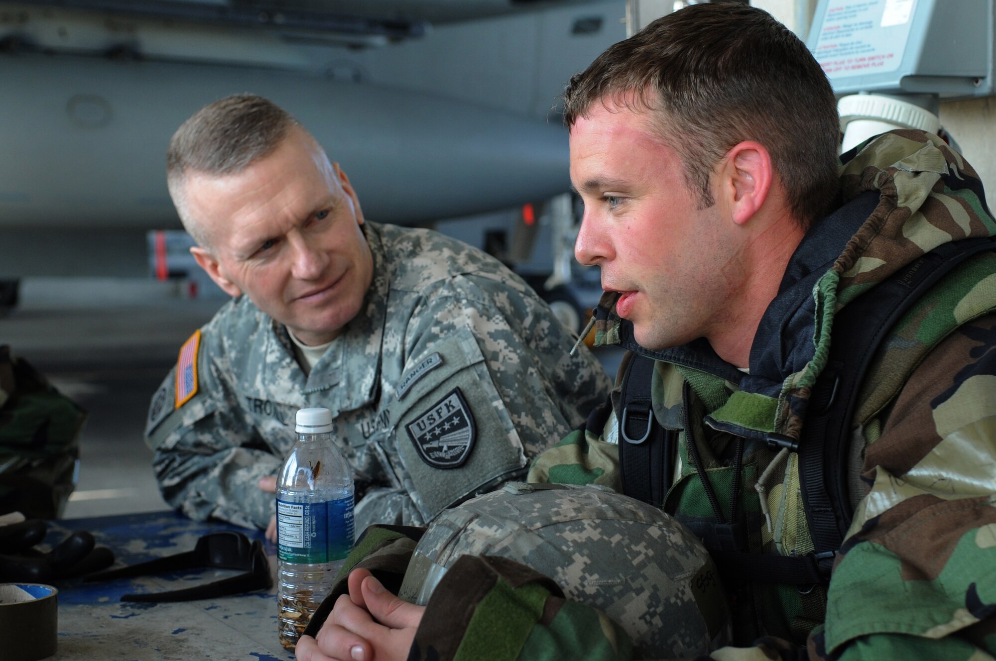 U.S. Army Command Sgt. Maj. John Troxell, United States Forces Korea command sergeant major, talks with U.S. Air Force Staff Sgt. Mark Brewer, 18th Aircraft Maintenance Squadron electric and environmental specialist, during a visit to Kadena Air Base, Japan, Jan. 30, 2014. Troxell toured the 18th Wing and spoke with Airmen about how their mission on Kadena supports the men and women serving in Korea. (U.S. Air Force photo by Staff Sgt. Amber E. N. Jacobs)