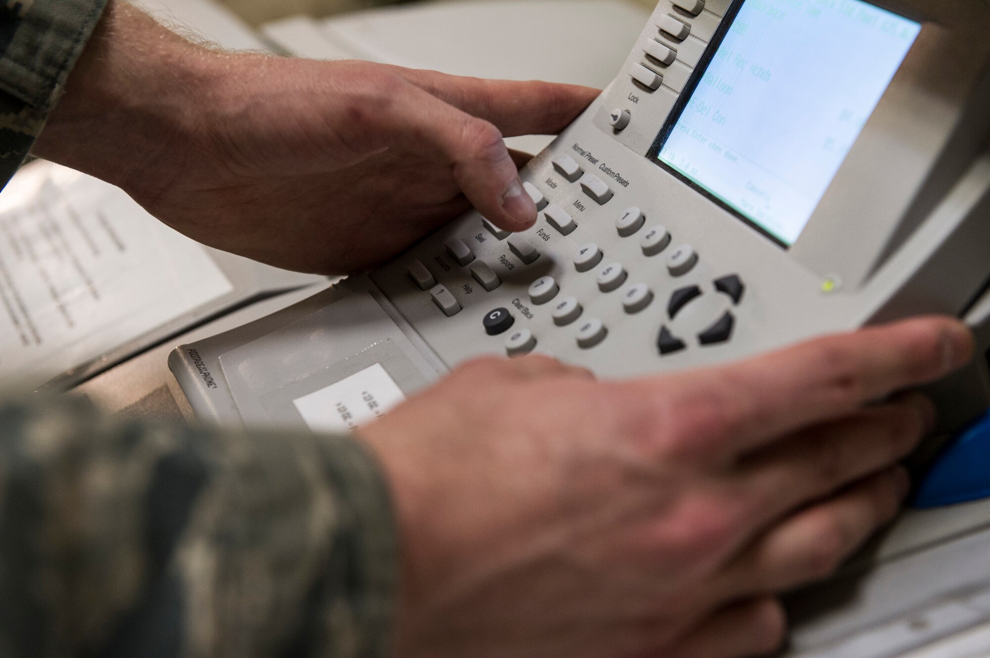 U.S. Air Force Senior Airman Joseph McConnell, 354th Communications Squadron knowledge operations management journeyman, prepares a postage meter Jan. 21, 2014, Eielson Air Force Base, Alaska. Postage meters aid the mail room by weighing packages and placing postage on mail. (U.S. Air Force photo by Senior Airman Joshua Turner/Released)