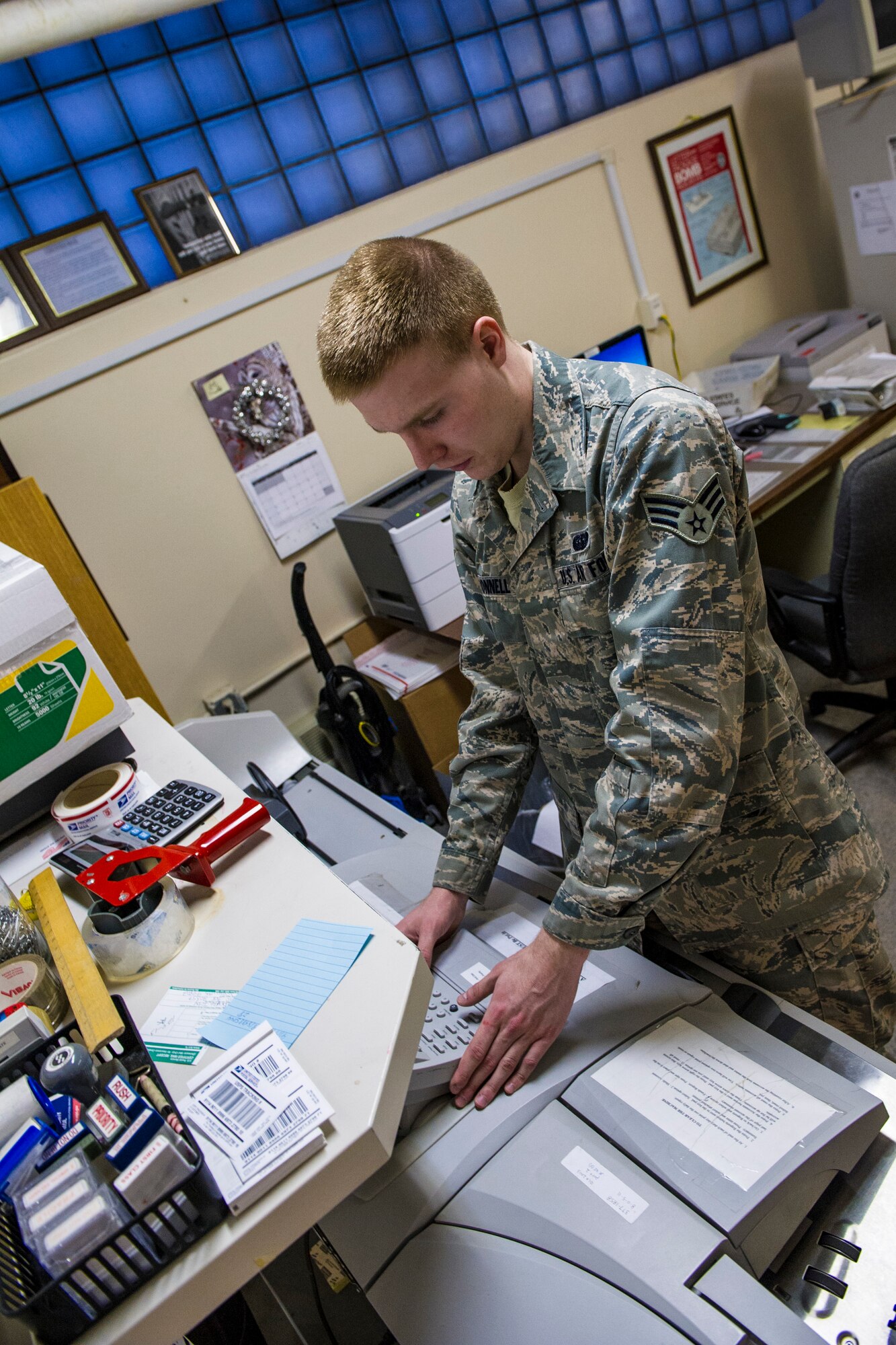 U.S. Air Force Senior Airman Joseph McConnell, 354th Communications Squadron knowledge operations management journeyman, prepares a postage meter Jan. 21, 2014, Eielson Air Force Base, Alaska. The postage meter aids the mail room by weighing packages and placing postage on mail. (U.S. Air Force photo by Senior Airman Joshua Turner/Released)