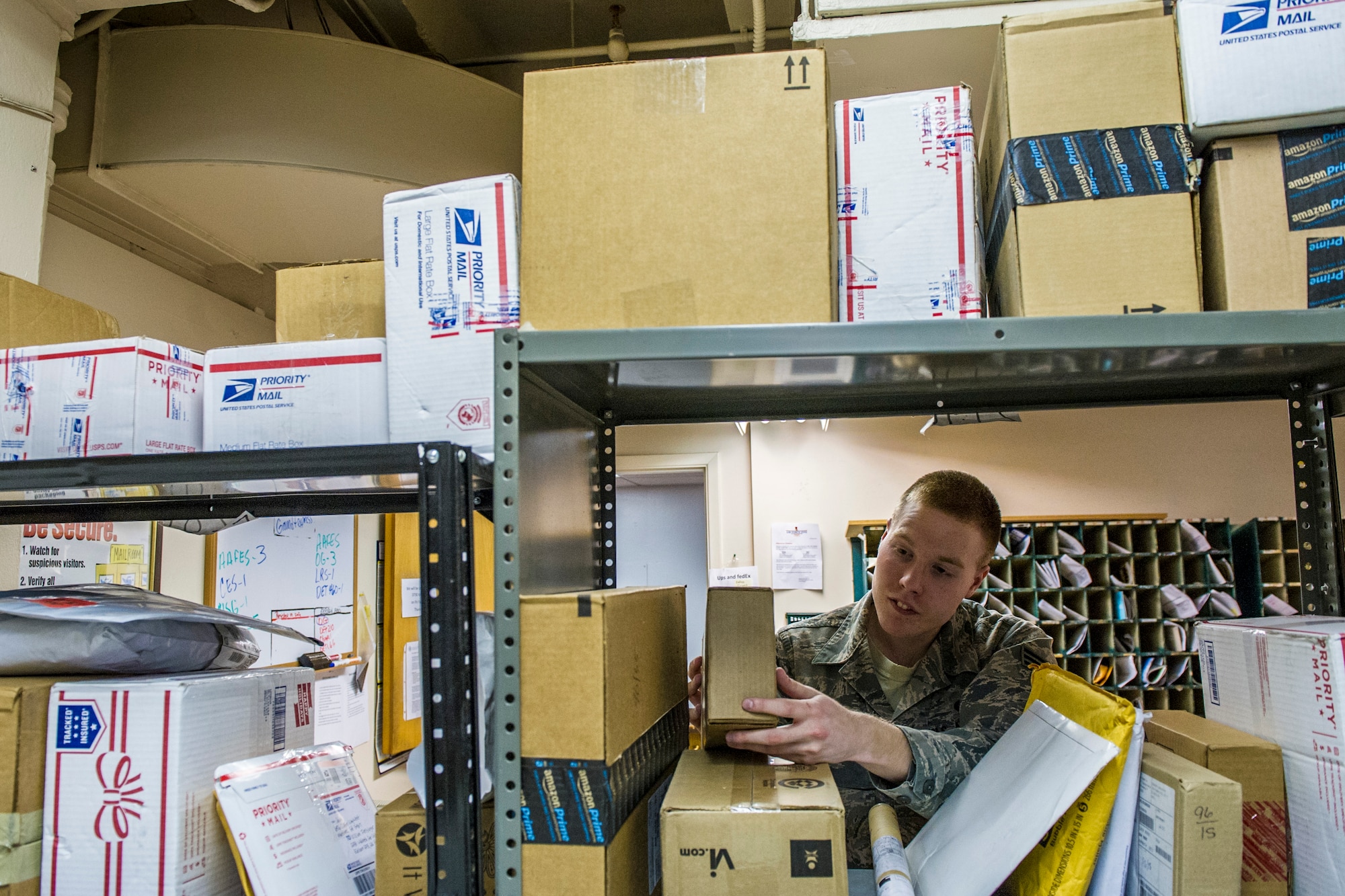 U.S. Air Force Senior Airman Joseph McConnell, 354th Communications Squadron knowledge operations management journeyman, looks for a package Jan. 21, 2014, Eielson Air Force Base, Alaska. Sorting dorm residents’ mail is one of many tasks knowledge operations managers complete daily. (U.S. Air Force photo by Senior Airman Joshua Turner/Released)