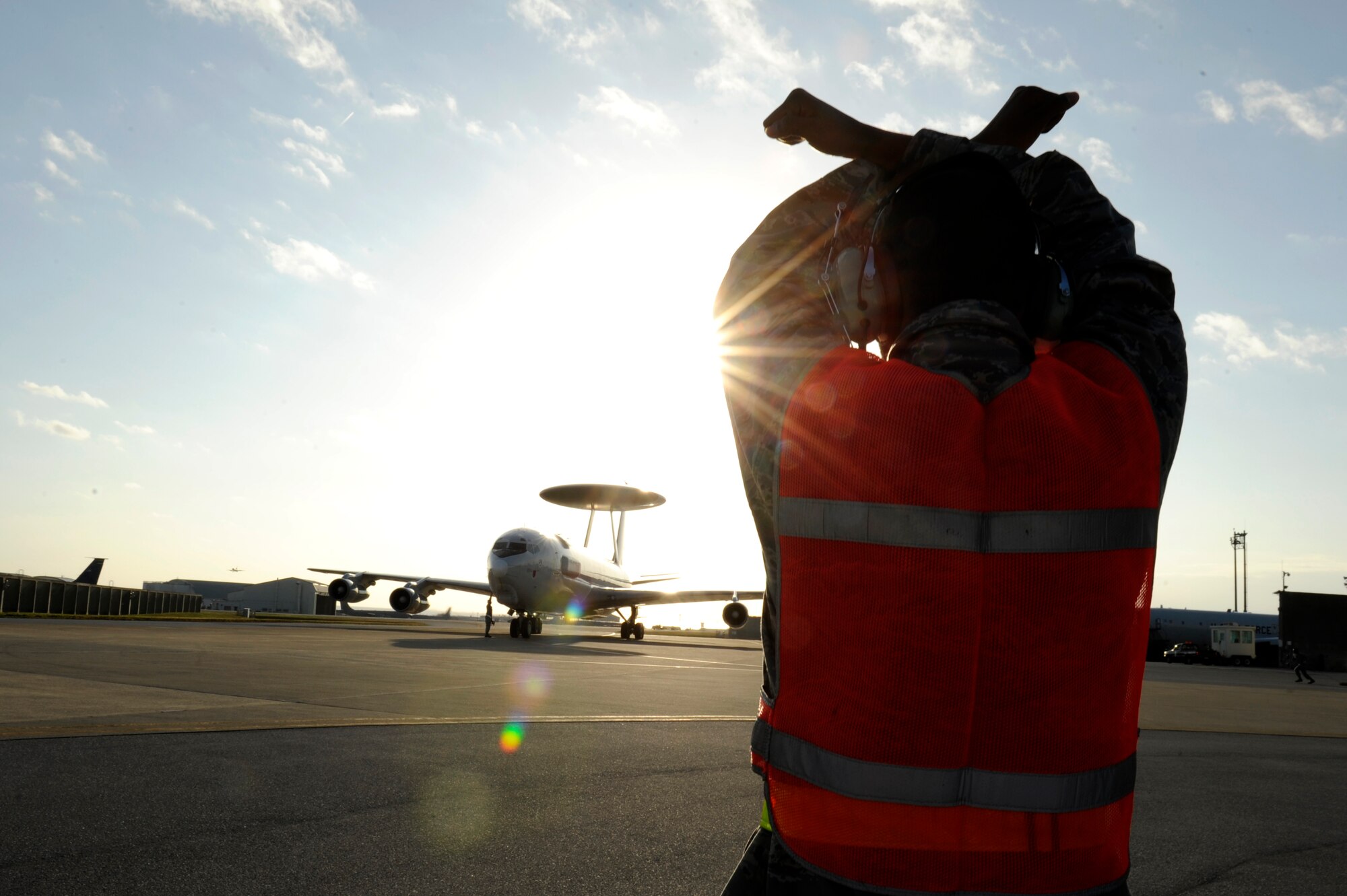 U.S. Air Force Airman 1st Class Quincy Jackson, 961st Aircraft Maintenance Unit crew chief, signals a 961st Airborne Air Control Squadron E-3 Sentry Airborne Warning and Control aircraft to halt on the Kadena Air Base, Japan, flightline Jan. 28, 2014. With its surveillance and reconnaissance mission, the AWACS aircraft from the 961st AACS provide Kadena visibility of virtually everything in the air and allows Kadena and other Air Force assets to project superior force for any operation. (U.S. Air Force photo by Senior Airman Maeson L. Elleman)