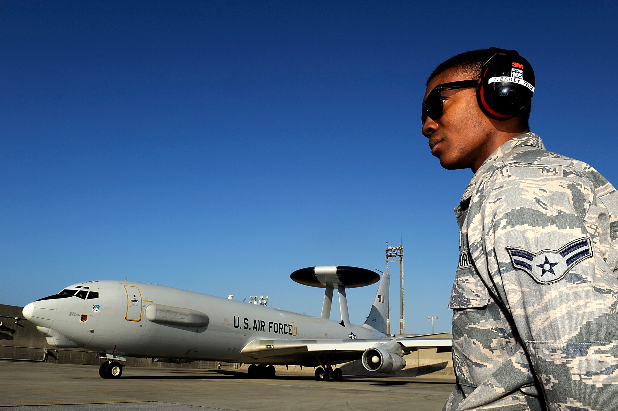 U.S. Air Force Airman 1st Class Timothy Bailey, 961st Aircraft Maintenance Unit propulsion technician, waits to marshal a 961st Airborne Air Control Squadron E-3 Sentry Airborne Warning and Control aircraft onto the Kadena Air Base, Japan, flightline Jan. 28, 2014. With its surveillance and reconnaissance mission, the AWACS aircraft from the 961st AACS provide Kadena visibility of virtually everything in the air and allows Kadena and other Air Force assets to project superior force for any operation. (U.S. Air Force photo by Senior Airman Maeson L. Elleman)