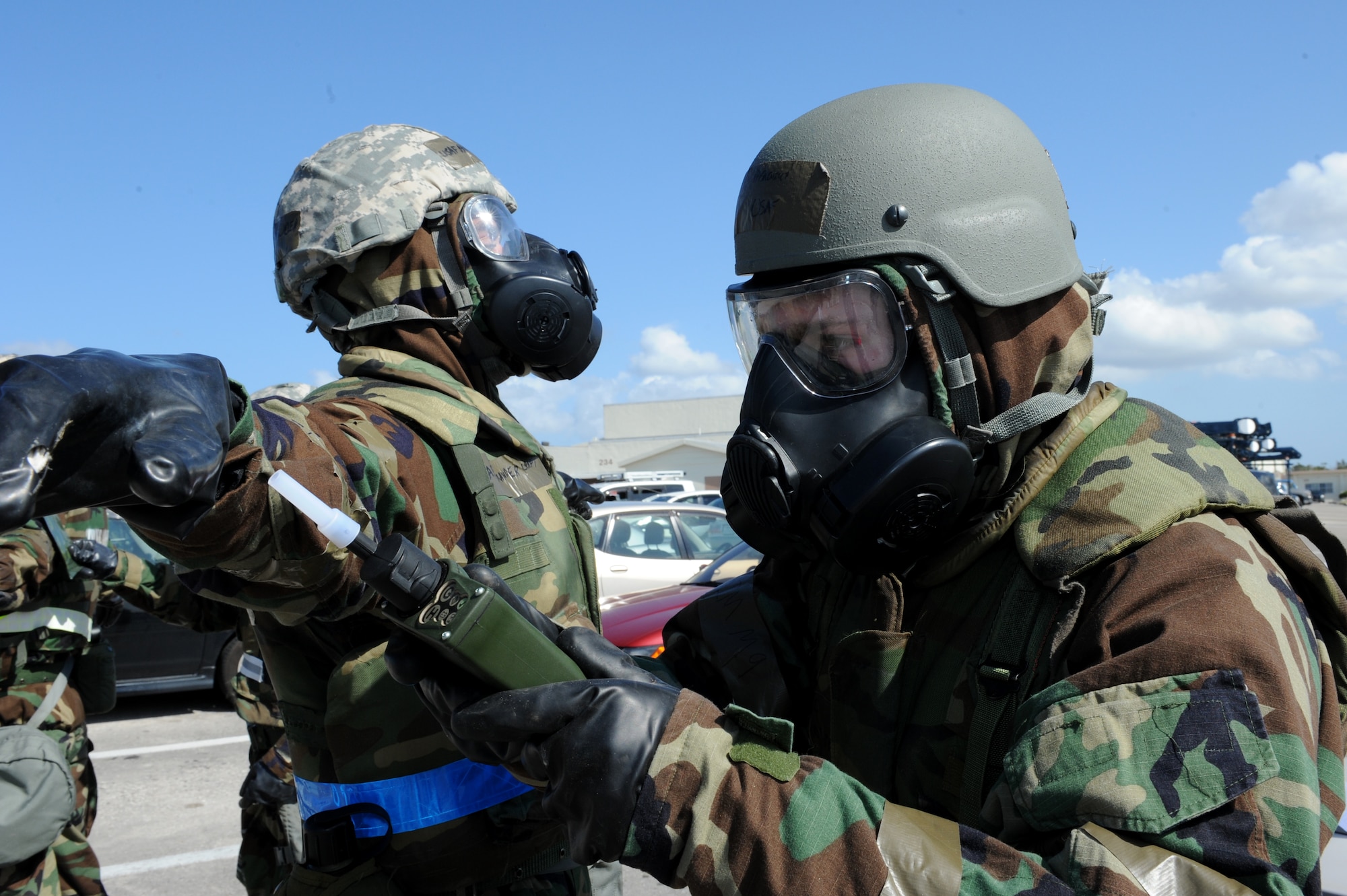 U.S. Air Force Airman 1st Class Zachary Paskovitch, 18th Civil Engineer Squadron emergency management responder, monitors an Airman who is simulating being contaminated with hazardous chemicals during a Mission Focused Exercise on Kadena Air Base, Japan, Jan. 30, 2014. Airmen who have been contaminated must report to a contamination control area where members from the 18th CES emergency management team will safely monitor and decontaminate them, returning them to their units with new gear so they can continue their mission. (U.S. Air Force photo by Airman 1st Class Hailey R. Staker)