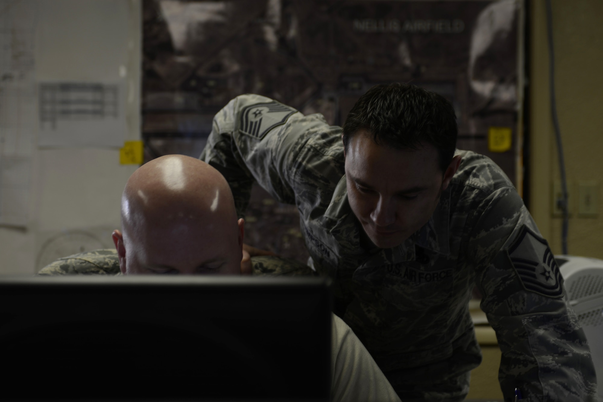Tech. Sgt. Russell Phillips, 366th Maintenance senior weapons system controller and Master Sgt. Jeramie Simpson, 366th MXG maintenance operations center NCO in charge, both from Mountain Home Air Force Base, Idaho, look through information regarding aircraft maintenance during from throughout the day’s flying at Red Flag 14-1 Jan. 29, 2014, at Nellis Air Force Base, Nev. Red Flag is a realistic combat training exercise involving the air forces from the United States and its allies. (U.S. Air Force photo by Senior Airman Benjamin Sutton/Released)