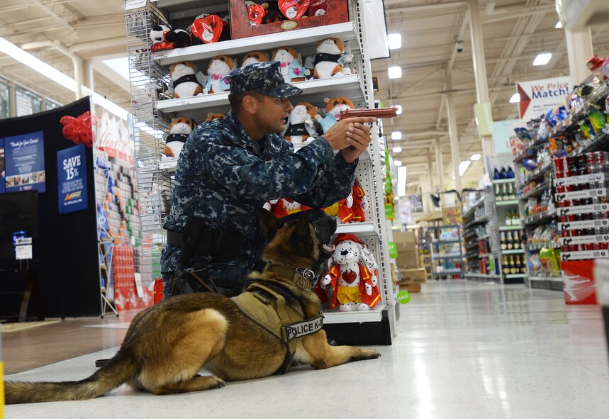 Navy Master of Arms Third Class Chris Rivera, posts with his K-9 and provides security during a Joint Exercise Evaluation Training Team active shooter exercise at Joint Base, Pearl Harbor-Hickam, Hawaii, Jan. 29, 2014. The participants included exercise evaluators, Navy police observers, actors playing the roles of shooters and casualties, and first responders from both the Hickam and Pearl Harbor security and police forces. The training enhanced first responder capabilities, and improved security communication and coordination between Hickam and Pearl Harbor. (U.S. Air Force photo/Staff. Sgt. Alexander Martinez)