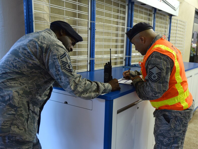 Senior Master Sgt. Christopher Hurst, 647th Security Forces Squadron manager, and Master Sgt. Robert Wooderson, noncommissioned officer in charge of the 647th SFS Standardization and Evaluations Team, make notes while they observe the Joint Exercise Evaluation Training Team active shooter exercise at Joint Base, Pearl Harbor-Hickam, Hawaii, Jan. 29, 2014. The participants included exercise evaluators, Navy police observers, actors playing the roles of shooters and casualties, and first responders from both the Hickam and Pearl Harbor security and police forces. The training enhanced first responder capabilities, and improved security communication and coordination between Hickam and Pearl Harbor. (U.S. Air Force photo/Staff. Sgt. Alexander Martinez)