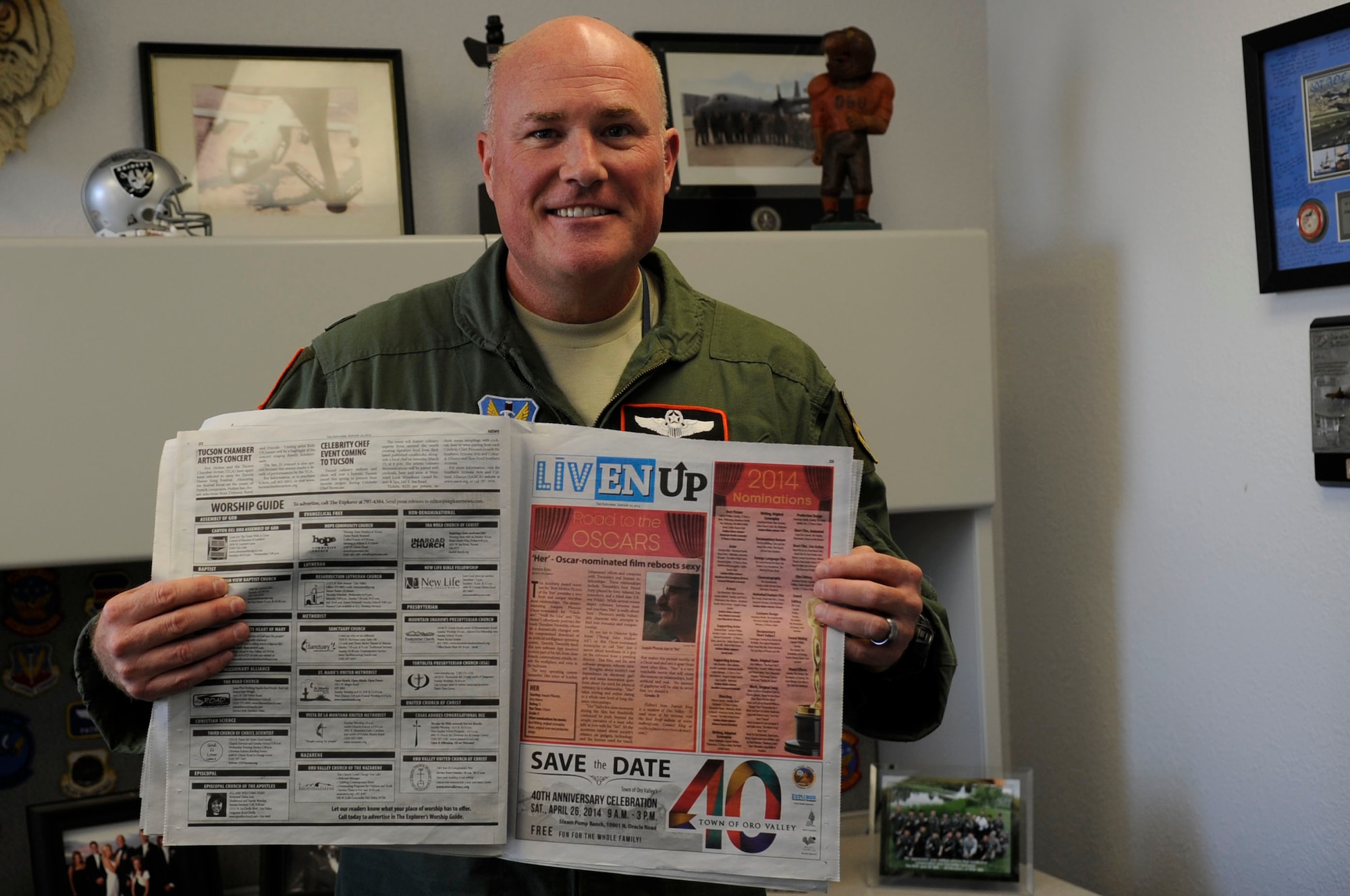 U.S. Air Force Lt. Col. Patrick King, 755th Operations Support Squadron assistant director of operations, holds up a newspaper containing his most recent movie review at Davis-Monthan Air Force Base, Ariz., Jan. 28, 2013. King started writing movie reviews as a hobby on Facebook in 2010 and recently got hired by Explorer Newspaper to write weekly reviews. (U.S. Air Force photo by Airman 1st Class Betty R. Chevalier/released)