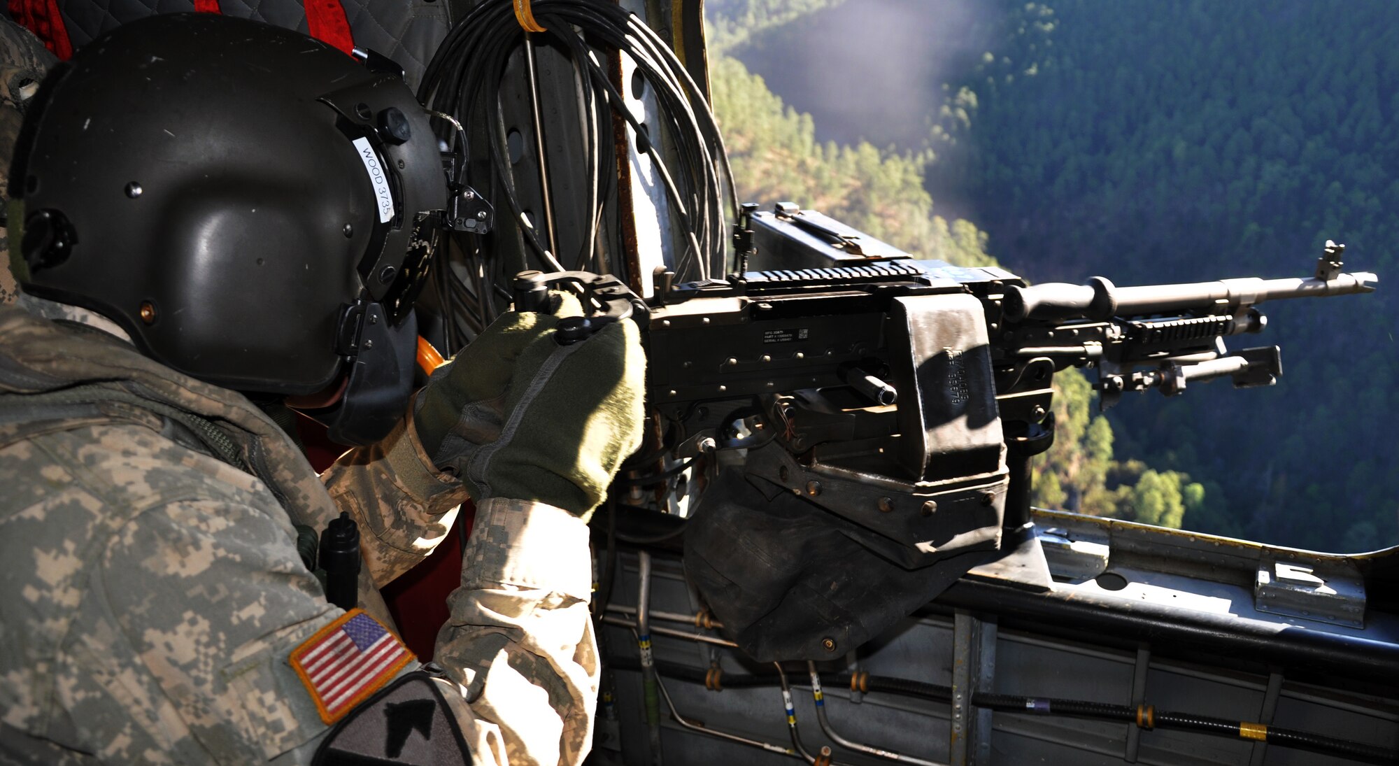 U.S. Army Sgt. Stegan Wood, CH-47 a flight engineer assigned to Joint Task Force-Bravo's 1-228th Aviation Regiment, fires an M240 machine gun from a CH-47 Chinook helicopter during aerial gunnery training, Jan. 29, 2014.  Members of the 1-228th conduct aerial gunnery training regularly in order to maintain currency and proficiency on the weapon system.  (U.S. Air Force photo by Capt. Zach Anderson)  