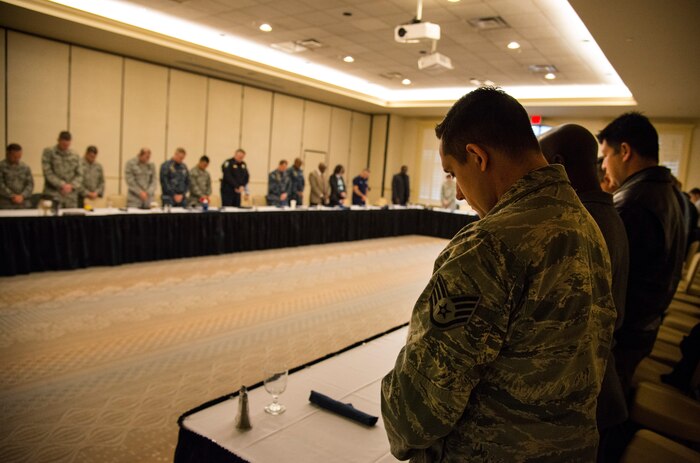 Attendees bow their heads during the invocation of the meeting between Airmen from the 628th Security Forces Squadron and local police agencies Jan. 23, 2014 at the Charleston Club on Joint Base Charleston – S.C. The intent of the meeting was to strengthen relationships between the local agencies and to improve teamwork. (U.S. Air Force photo by Airman 1st Class Clayton Cupit)