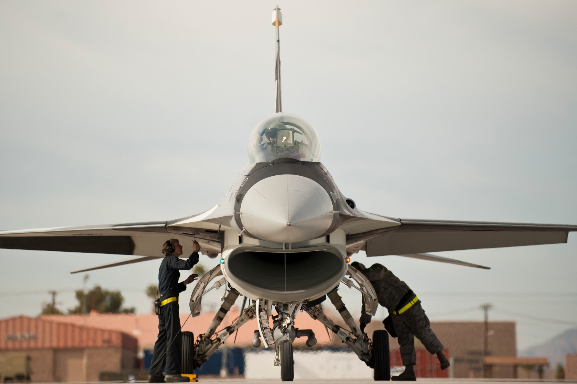 Aircraft maintainers from the 757th Aircraft Maintenance Squadron Viper Aircraft Maintenance Unit, perform preflight checks on an F-16 Fighting Falcon from the 64th Aggressor Squadron before a Red Flag 14-1 training mission Jan. 29, 2014, at Nellis Air Force Base Nevada. Pilots of the 64th AGRS are trained in the use of adversary tactics and act as part of the “Red Force” during Red Flag exercises. Red Flag provides realistic combat training in a contested, degraded and operationally limited environment providing real-time war scenarios. (U.S. Air Force photo by Airman 1st Class Joshua Kleinholz)