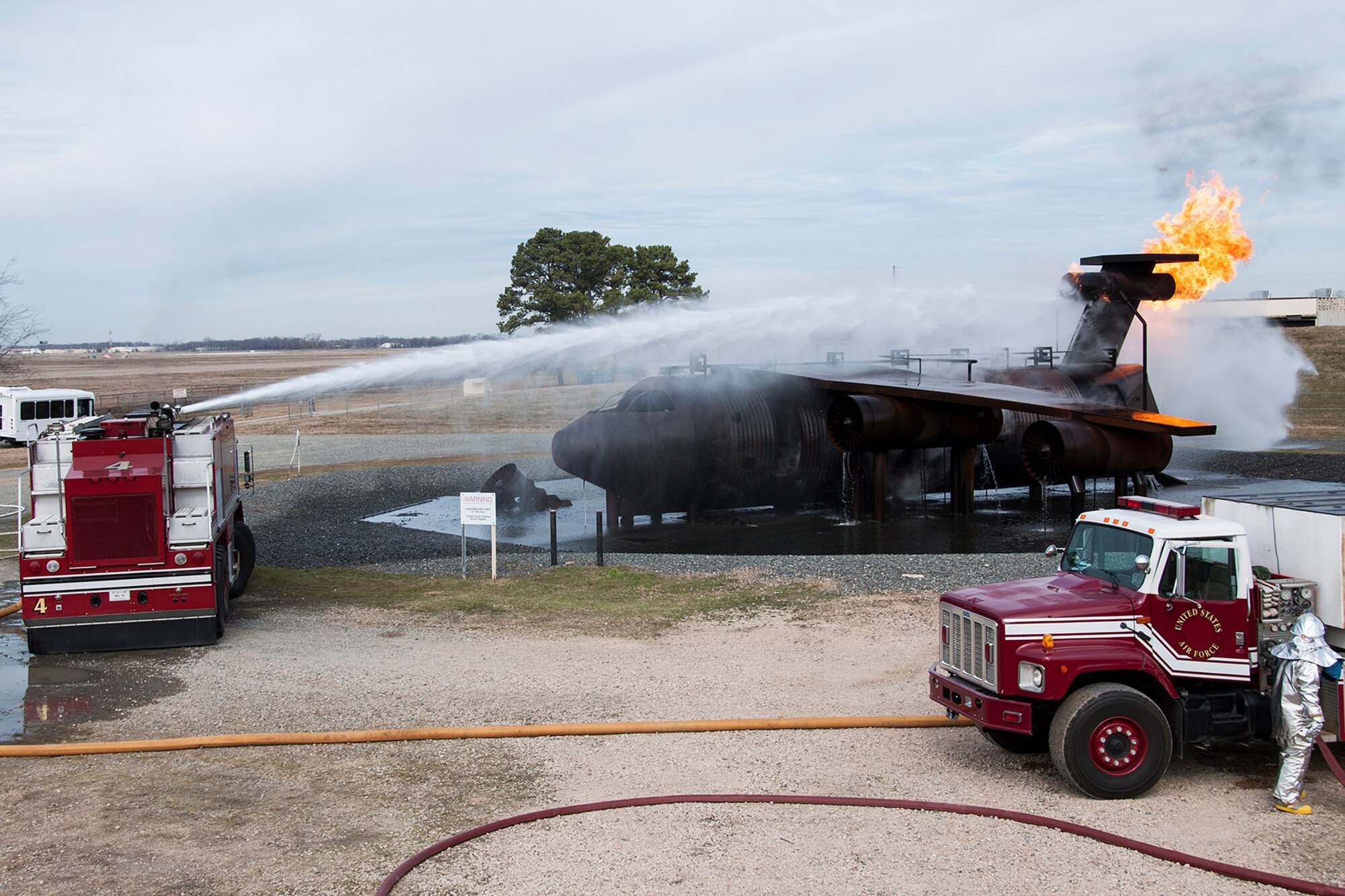 Firemen assigned to the 307th Civil Engineer Squadron practice extinguishing a fire on a large frame aircraft trainer, Jan. 26, 2014, Barksdale Air Force Base, La. The firefighters are assisted by visiting Maj. Gen. Robert Rego, Air Force Global Strike Command vice commander, who is operating the fire truck water cannon. (U.S. Air Force photo by Tech. Sgt. Ted Daigle/Released)