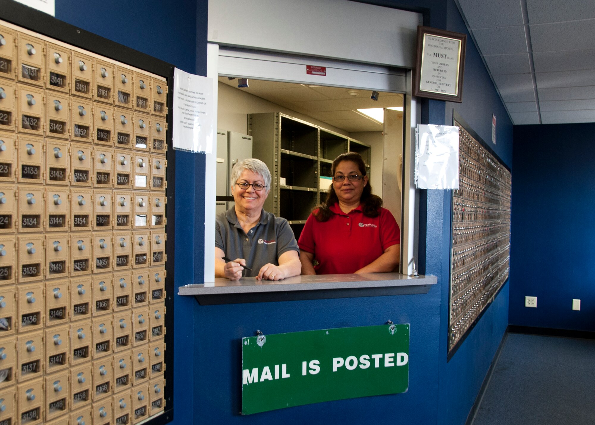 ALTUS AIR FORCE BASE, Okla. – Patricia Ellsworth and Linda Colon, Principle Technologies Inc. employees, pose for a photo at the U.S. Postal Service Center Jan. 30, 2014. The base postal service center provides mailboxes for all dormitory, temporary duty and incoming Airmen without a home address. (U.S. Air Force photo by Senior Airman Franklin R. Ramos/Released)
