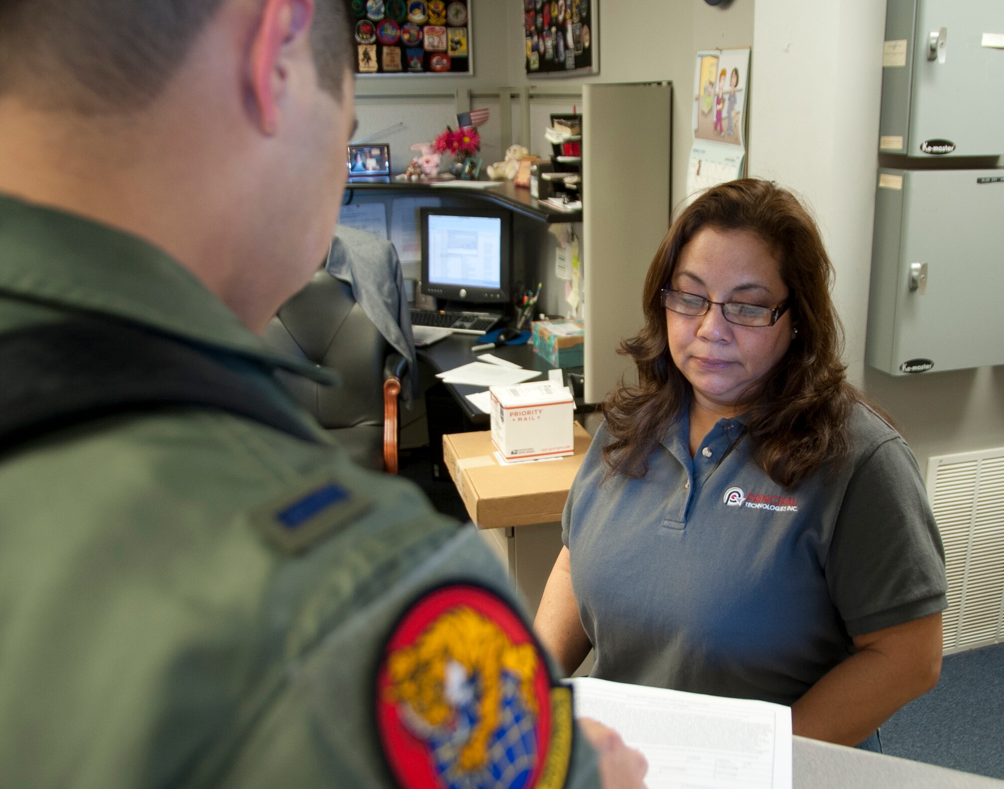 ALTUS AIR FORCE BASE, Okla. – Linda Colon, Principle Technologies Inc. employee manager, gathers information from an out-processing Airman at the base U.S. Postal Service Center, Jan. 29, 2014.The base postal service center gathers information such as the next home of address from out-processing Airmen so all  of their received mail can be forwarded. (U.S. Air Force photo by Senior Airman Franklin R. Ramos/Released) 