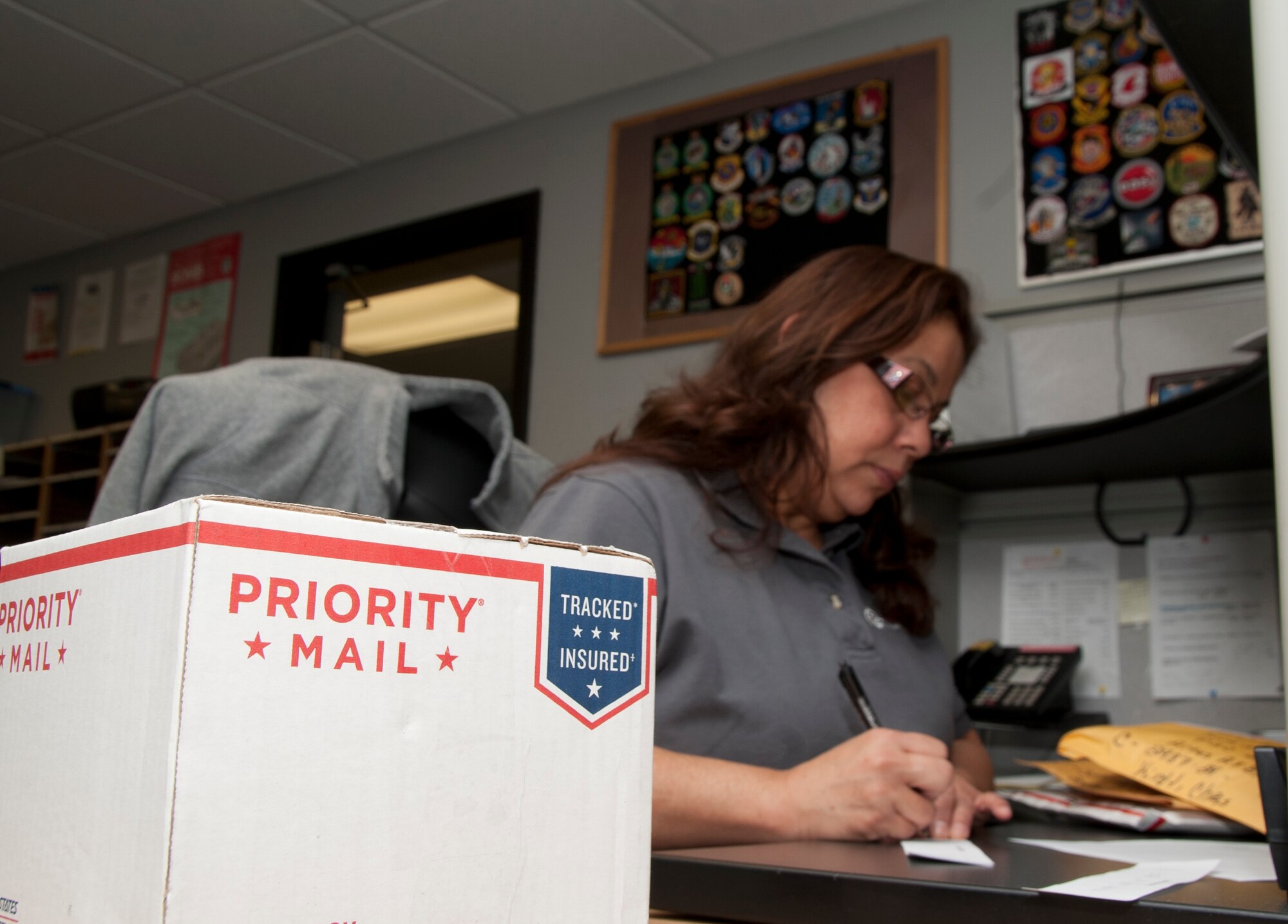 ALTUS AIR FORCE BASE, Okla. – Linda Colon, Principle Technologies Inc. employee manager, creates package sign-out slips at the base U.S. Postal Service Center Jan. 29, 2014. Slips are left inside individuals’ mailboxes that have packages awaiting pick-up. Individuals are required to turn in the slips and sign for their package for accountability and security purposes. (U.S. Air Force photo by Senior Airman Franklin R. Ramos/Released)