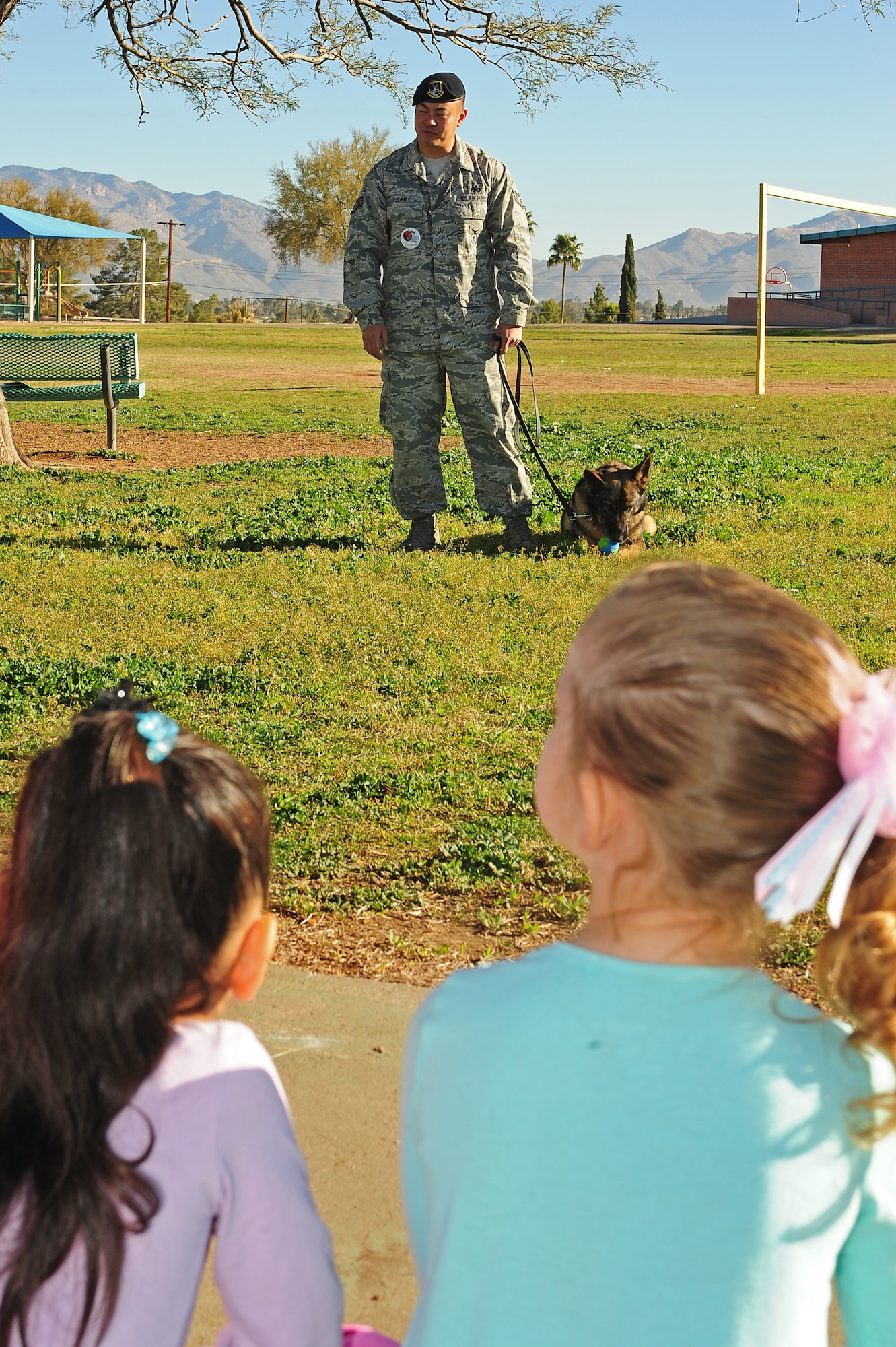U.S. Air Force Staff Sgt. Ki Nam, 355th Security Forces Squadron Military Dog handler, brought his partner, Benny, 355th SFS MWD, to career day at Dietz Elementary School, Tucson, Ariz., Jan. 29, 2014. Nam spoke to the children about what it means to be a dog handler and Benny demonstrated some obedience training. (U.S. Air Force photp by Senior Airman Camilla Elizeu/Released)