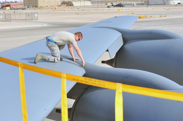 Staff Sgt. Mark Lash, 22nd Aircraft Maintenance Squadron crew chief, performs aircraft preparation to launch the KC-135 Stratotanker during Red Flag 14-1 at Nellis Air Force Base, Nev., Jan. 28, 2014. Red Flag is a realistic combat training exercise that incorporates air, space and cyber forces as part of the blue forces and their adversaries, the red forces. (U.S. Air Force photo by Staff Sgt. Veronica Montes/Released)