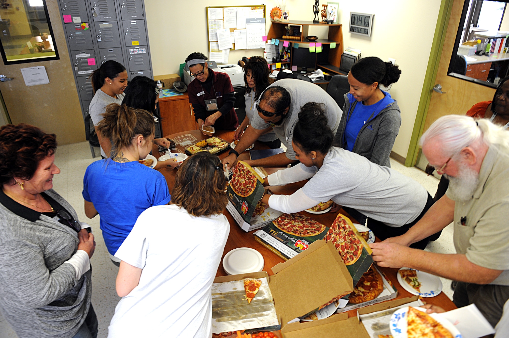 The School Age Program staff load their plates with pizza during an appreciation day at Davis-Monthan Air Force Base, Ariz., Jan. 28, 2014. The School Age Program focuses on providing children with a constructive and engaging environment before and after school. (U.S. Air Force photo by Airman 1st Class Chris Drzazgowski)