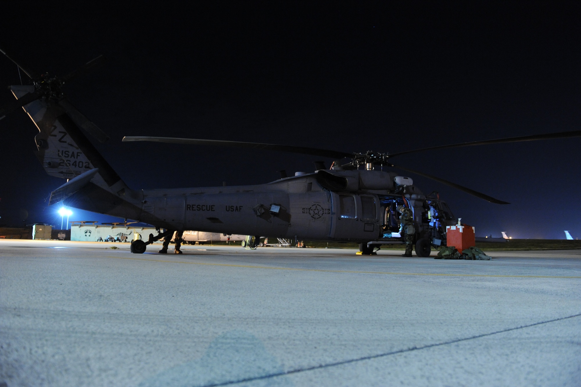 33rd Helicopter Mintenance Unit members inspect and prepare an HH-60G Pave Hawk helicopter while wearing mission-oriented protective posture gear on the Kadena Air Base, Japan, flightline during a Mission Focused Exercise Jan. 30, 2014. MFEs test Airmen's skills during wartime contingencies and scenarios to ensure Airmen can perform their duties in any situation. (U.S. Air Force photo by Airman 1st Class Keith James)