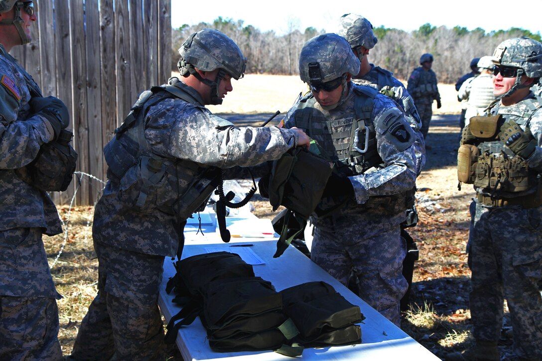 Army Sgt. Celestino Rivera, center right, is issued an M18A1 Claymore mine at a range during a live-fire exercise on the final day of Spider Munitions System training on Fort Campbell, Ky., Jan. 24, 2014. Rivera, a combat engineer, is assigned to the 101st Airborne Division's 326th Engineer Battalion, 1st Brigade Combat Team.