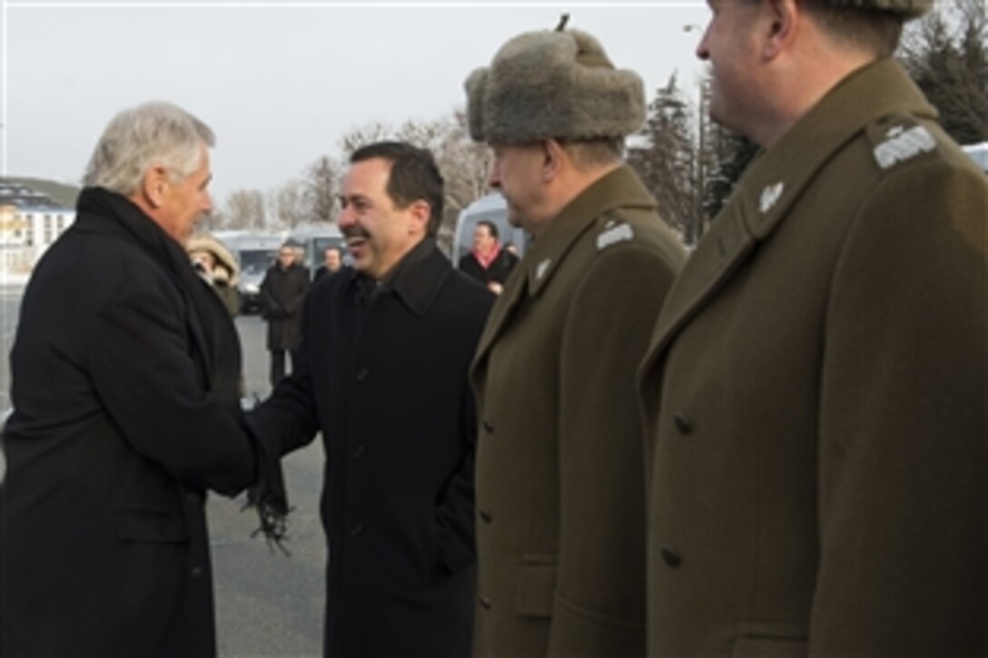 U.S. Defense Secretary Chuck Hagel, left, is greeted by U.S. Ambassador to Poland Stephen Mull at Warsaw Chopin Airport in Warsaw, Poland, Jan. 30, 2014.