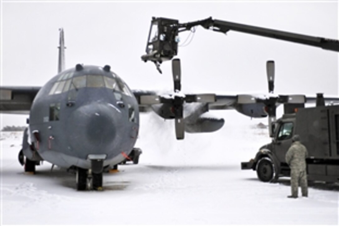 Air Force personnel remove snow and ice from the wings and propellars of a aircraft following a snowstorm on Francis S. Gabreski Air National Guard Base, Westhampton, New York, Jan. 29, 2014. The airmen are assigned to the 106th Rescue Wing's Civil Engineering Squadron.