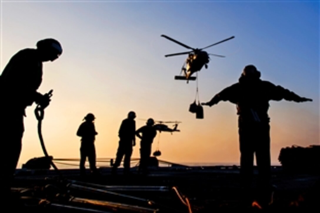 U.S. sailors direct an MH-60S Knighthawk helicopter to the flight deck of the aircraft carrier USS Harry S. Truman during a replenishment in the Gulf of Oman, Jan. 29, 2014. The Truman is deployed to the U.S. 5th Fleet area of responsibility conducting maritime security operations, supporting theater security cooperation efforts and supporting Operation Enduring Freedom. 