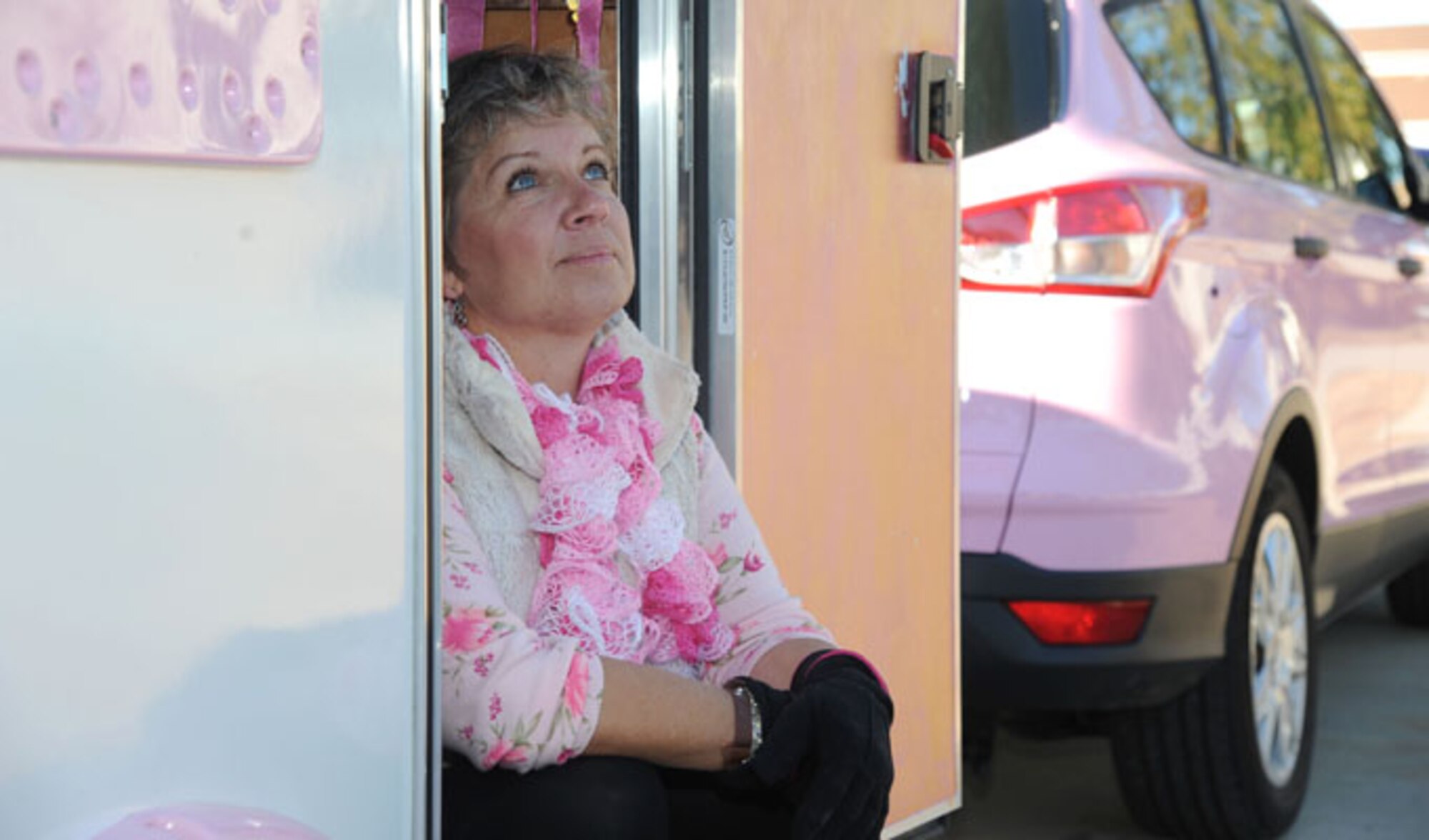 Alison Miller, widow of retired Master Sgt. Chuck Dearing, sits in the doorway of her pink painted teardrop trailer during a travel break Jan. 16, 2014, at the Keesler Air Force Base camp site, Biloxi, Miss. Following Dearing’s retirement, the couple sold their home and belongings and traveled the country for four years staying primarily in base lodgings. Prior to the death of her husband, Miller told him that her intent was to continue traveling in a pink painted car so that he could find her while out on the road. (U.S. Air Force photo/Kemberly Groue)
