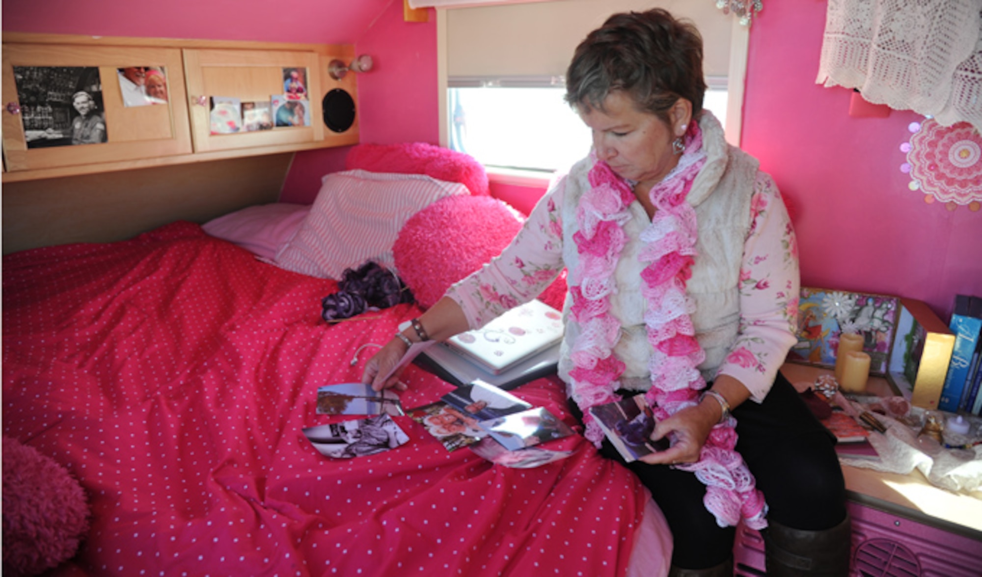 Alison Miller, widow of retired Master Sgt. Chuck Dearing, sorts through photos of herself and Dearing inside of her pink painted teardrop trailer during a travel break Jan. 16, 2014, at the Keesler Air Force Base camp site, Biloxi, Miss. Following Dearing’s retirement, the couple sold their home and belongings to travel the country for four years, staying primarily at base lodgings. Prior to the death of her husband, Miller told him that her intent was to continue traveling in a pink painted car so that he could find her while out on the road. (U.S. Air Force photo/Kemberly Groue)
