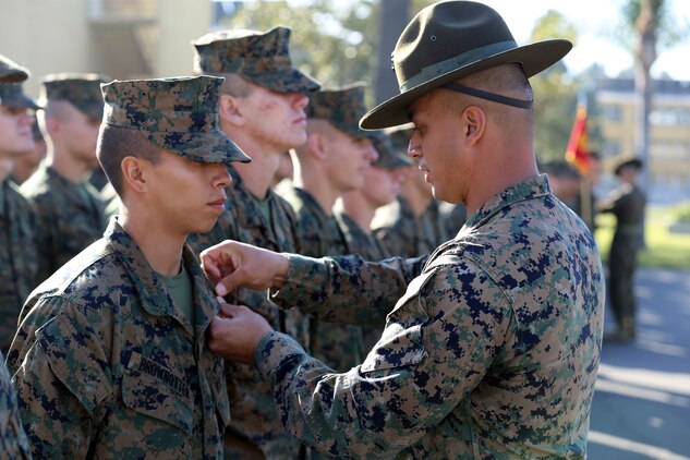Lance Cpl. Cristian J. Brown-otter, company honorman, Platoon 1042, Company C, 1st Recruit Training Battalion, is meritoriously promoted by Staff Sgt. Scott P. Henryson, senior drill instructor, during a promotion ceremony aboard the depot, Jan. 22. During recruit training, the company honor man is usually meritoriously promoted to the next higher rank.