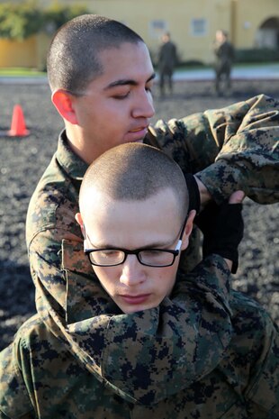 Recruits of Company L, 3rd Recruit Training Battalion, are evaluated on various choke techniques aboard the depot, Jan. 22.  The choke techniques utilized are just a small portion of numerous moves incorporated in the Marine Corps Martial Arts Program tan belt.