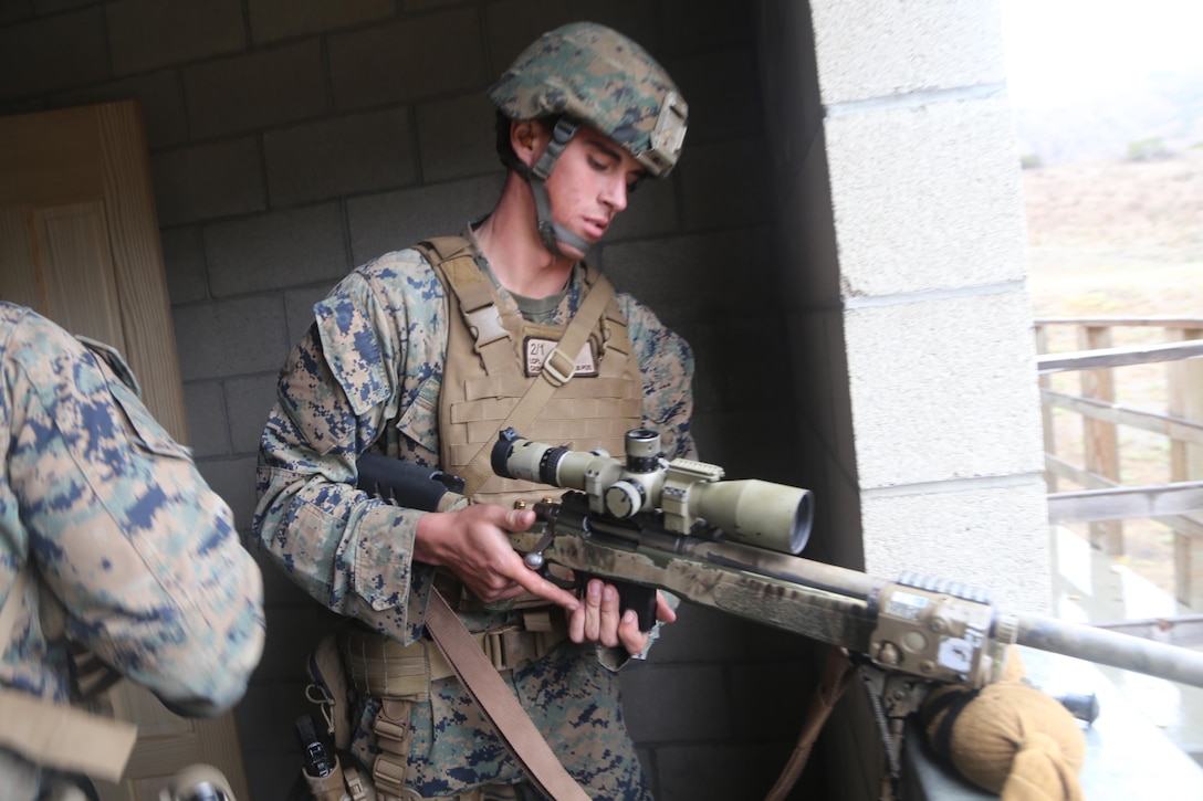 Lance Cpl. Christopher Cash, a scout sniper with 2nd Battalion, 1st Marines, now part of the 11th Marine Expeditionary Unit, loads his weapon during the sniper marathon course here Jan. 30.