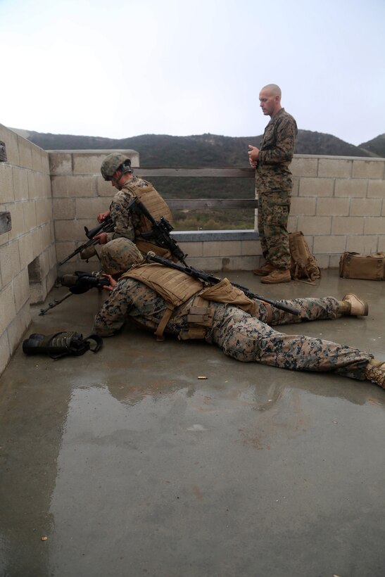 A sniper team with 2nd Battalion, 1st Marines, observes their target from a rooftop during the sniper marathon course here Jan. 30. The course consisted of engaging an unknown number of targets from elevated positions with various weapon systems.