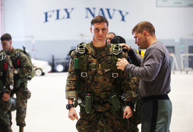 Sgt. David Tanney, the jump team leader with Bravo Company, 3rd Reconnaissance Battalion, 3rd Marine Division, gets his gear checked over in Hangar 105 before conducting high-attitude high-opening parachuting during Exercise Sandfisher, Jan. 28, 2014. The reconnaissance Marines jumped twice a day from a Lockheed C-130 Hercules aircraft, practicing skills and developing the correct methods and tactics while working as a team. (U.S. Marine Corps photo by Lance Cpl. Suzanna Knotts)