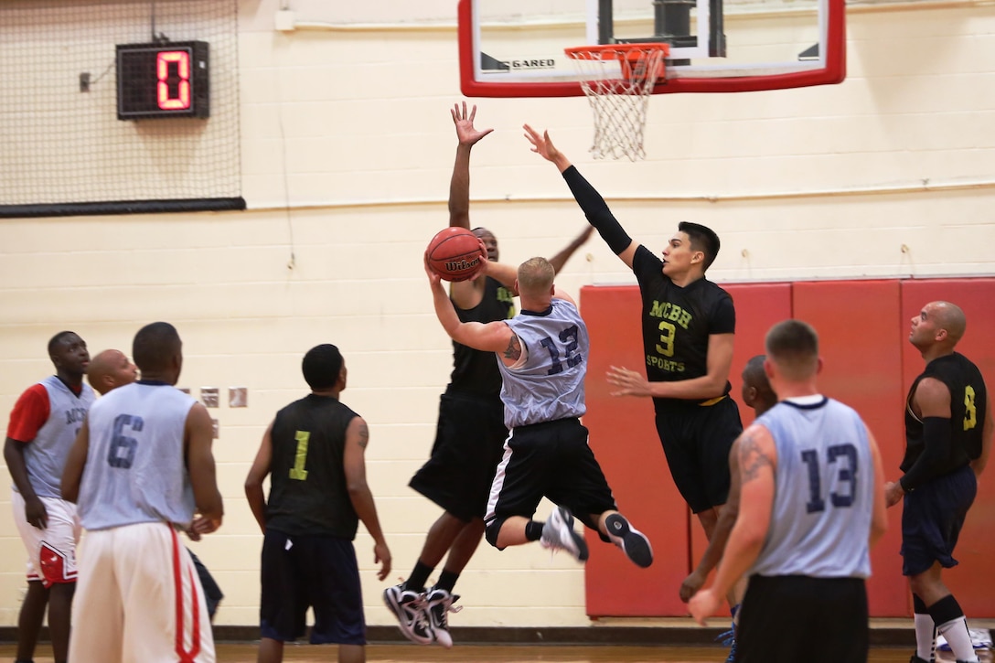 A 1st Battalion, 12th Marine Regiment player drives to the basket during an intramural basketball game against Marine Aviation Logistics Squadron 24 at the Semper Fit Center gym, Jan. 28, 2014. Both teams played hard, but MALS-24 was able to take the victory with a score of 48-26. (U.S. Marine Corps photo by Cpl. Nathan Knapke)