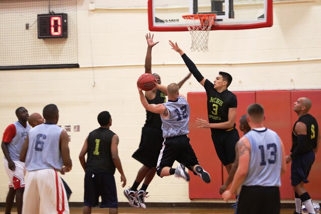 A 1st Battalion, 12th Marine Regiment player drives to the basket during an intramural basketball game against Marine Aviation Logistics Squadron 24 at the Semper Fit Center gym, Jan. 28, 2014. Both teams played hard, but MALS-24 was able to take the victory with a score of 48-26. (U.S. Marine Corps photo by Cpl. Nathan Knapke)