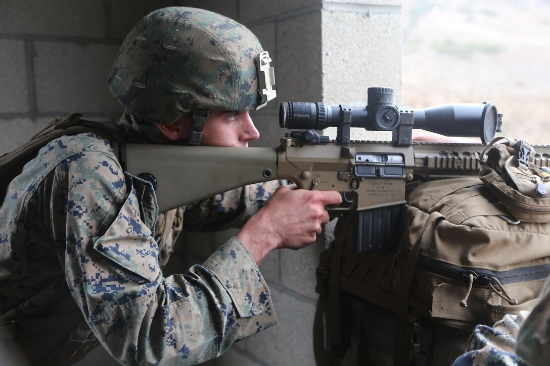 Lance Cpl. Christopher Cash, a scout sniper with 2nd Battalion, 1st Marines, now part of the 11th Marine Expeditionary Unit, participates in the sniper marathon course here Jan. 30. The course consisted of engaging an unknown number of targets from elevated positions with various weapon systems.