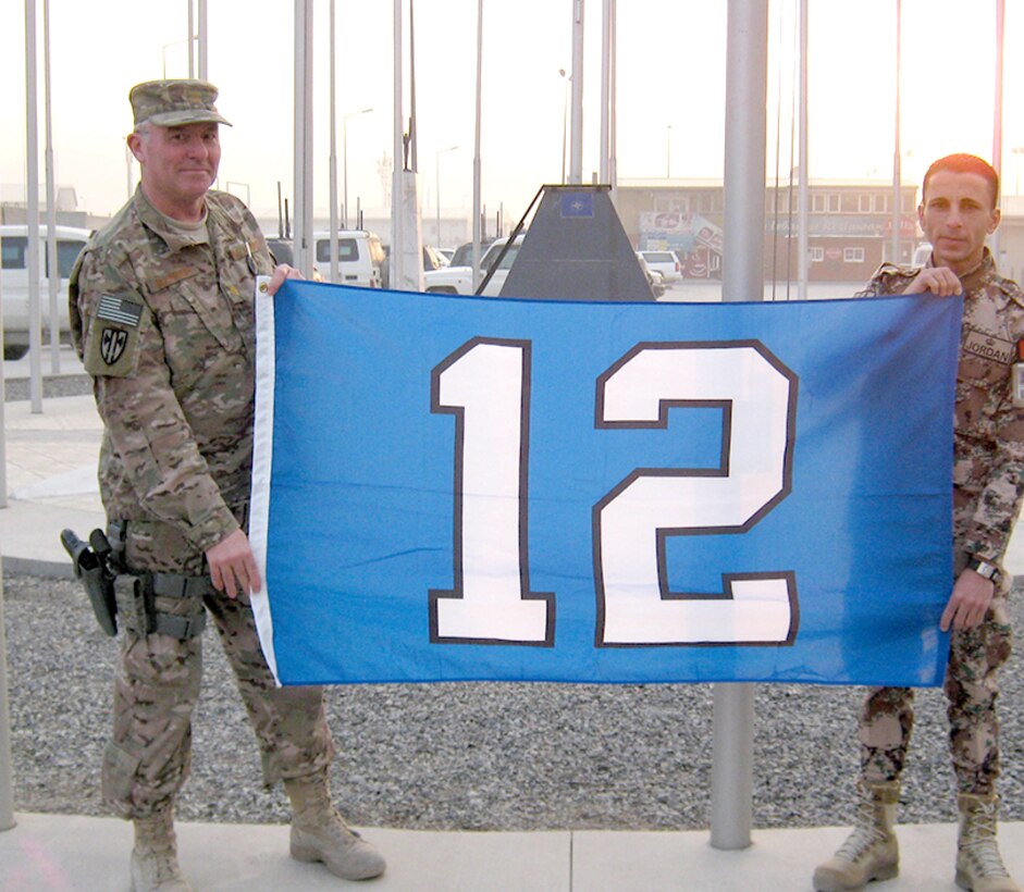 Maj. Ray Schierhoff, 446th Security Forces Squadron commander, holding his 12th Man flag in front of the NATO Headquarters in Kabul, Afghanistan, with one of his co-workers (who has no idea who the Seahawks are). (Courtesty photo)