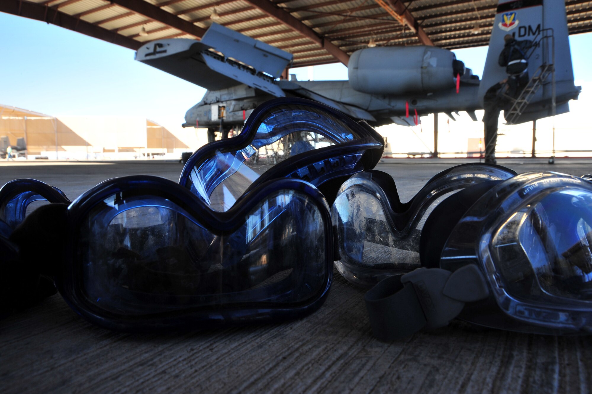 Safety goggles lie on the ground before the 355th Aircraft Maintenance Squadron’s leadership washes an A-10C Thunderbolt at Davis-Monthan Air Force Base, Ariz., Jan 28., 2014. Leadership made a deal with their Airmen that if the squadron went 60 days without any safety or technical violations they would wash the aircraft for them.(U.S. Air Force photo by Senior Airman Josh Slavin/released)
