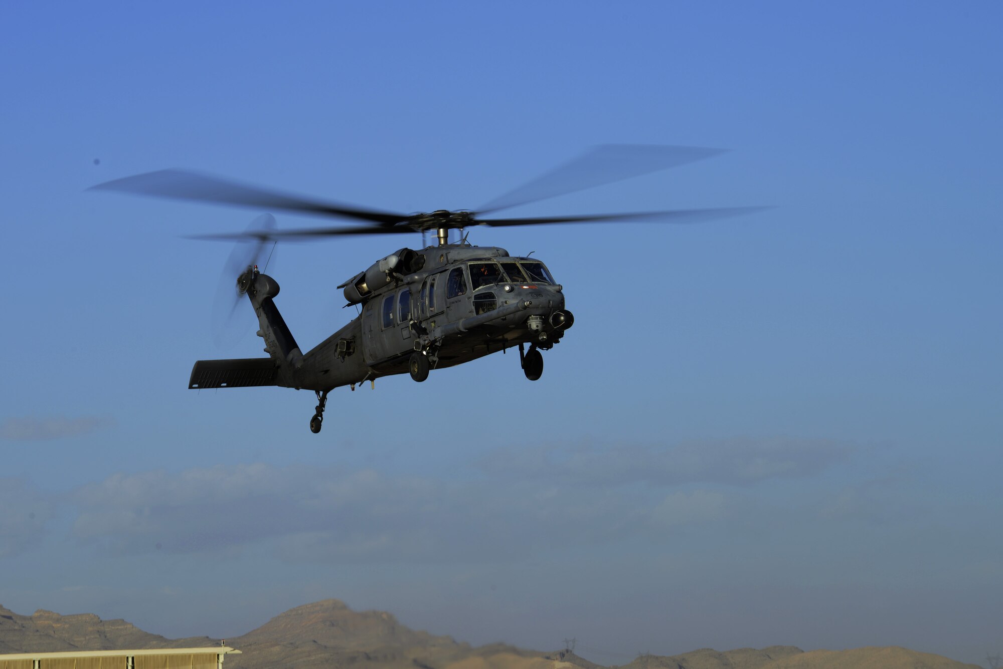 An HH-60 Pave Hawk from the 66th Rescue Squadron, Nellis Air Force Base, Nev., hovers while performing pre-flight inspections here Jan 30, 2014. The 66th RQS is currently supporting the combat exercise Red Flag 14-1. The exercise gives military members the opportunity to experience realistic, stressful combat situations in a controlled environment to increase their ability to complete missions and return home. (U.S. Air Force photo by Senior Airman Benjamin Sutton/Released) 
