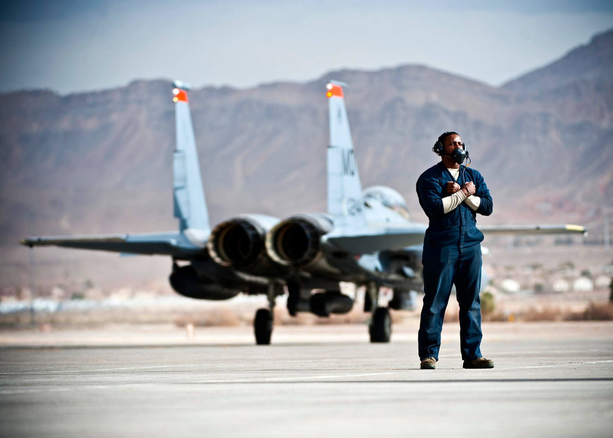 U.S. Air Force Senior Airman Oren Hemphill, 366th Aircraft Maintenance Squadron crew chief, Mountain Home Air Force Base, Idaho, waits to marshal an F-15E Strike Eagle during Red Flag 14-1 Jan. 30, 2014, at Nellis Air Force Base, Nev. Red Flag gives aircrews and air support operations service members from various airframes, military services and allied countries an opportunity to integrate and practice combat operations. (U.S. Air Force photo/Senior Airman Brett Clashman)